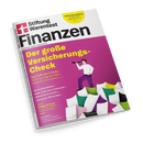 Schräg fotografierte Zeitschrift „Stiftung Warentest Finanzen“ mit weißem Cover, schwarzer Schrift und magentafarbener Titelfläche vor schwarzem Hintergrund. Aufschrift „Der große Versicherungs-Check“, dazu eine stilisierte Person mit kurzem braunem Haar und Fernrohr sowie Texte wie „Wertschließfächer“, „Mehr Netto beim Nebenjob“, „Bitcoin & Co kaufen“, „Betrug per WhatsApp“ und „Anlegen für Kinder“.