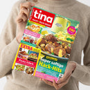 Person im beigefarbenen Strickpullover hält eine schräg ausgerichtete Zeitschrift mit beiden Händen. Auf dem farbigen Cover stehen „tina“, „Koch & Back-Ideen“ und „GENUSS FÜR JEDEN TAG“; sichtbar sind außerdem „Blechkuchen“, „Pasta-Glück“, „EXTRA“, „Super saftige Hack-Hits“ und „Mehr als 100 Rezepte“ sowie Fotos von Kuchen, Hackgerichten, Pasta und weiteren Speisen.