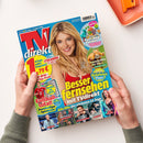 Deutschsprachige TV-Zeitschrift „TV direkt“ mit blau-rotem Cover, zentralem Foto einer blonden weiblichen Person und großen gelben Texten „Besser fernsehen mit TV direkt“. Weitere sichtbare Aufschriften: „14 Tage volles Programm“, „Streaming-Planer“, „Die Fett-weg-Formel“, „Superkräfte der Tiere“, „Fußball total! Bundesliga-Spielplan“ und „Mediatheken-Planer“; das Magazin wird von zwei Händen gehalten.