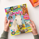 Schräg fotografiertes Pferde- und Pony-Poster aus Papier, von zwei Händen gehalten. Das farbenfrohe Cover zeigt ein weißes Pony und ein braunes Pferd sowie weitere Pferdefotos; sichtbare Texte sind „5 Sommer POSTER“, „Ponys“, „Pferde für Könige“, „SPASS am Strand“, „COMIC! Nur Ärger in den Ferien“ und „Spannung in der Fotostory!“.